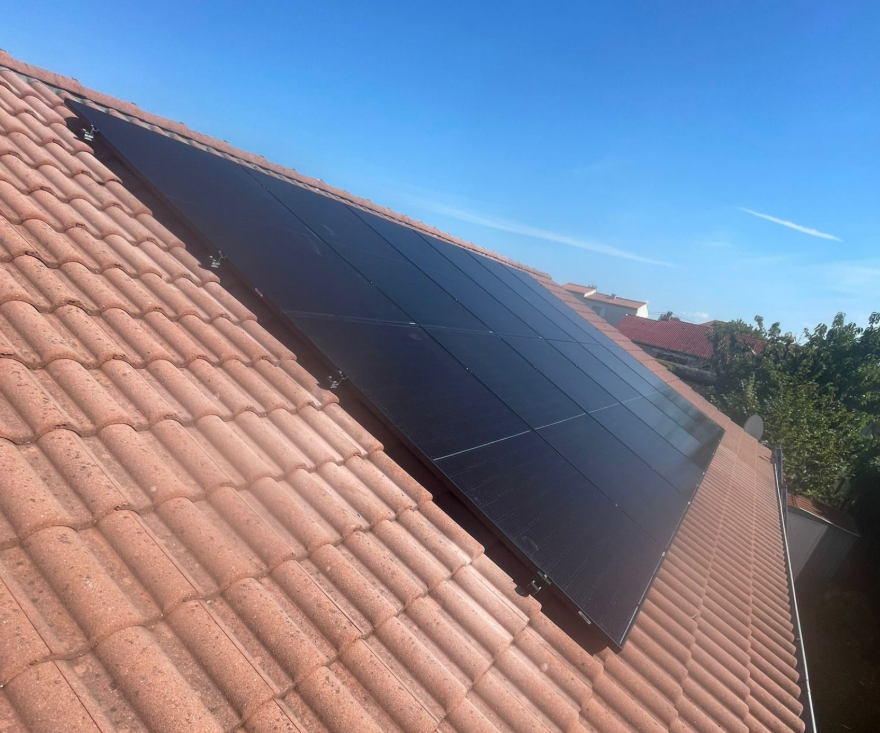 Pose de panneaux solaires full black alignés sur toiture inclinée en tuiles